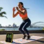 Australian fitness enthusiast performing a high-intensity interval training exercise outdoors with a mat and timer, representing modern HIIT workouts
